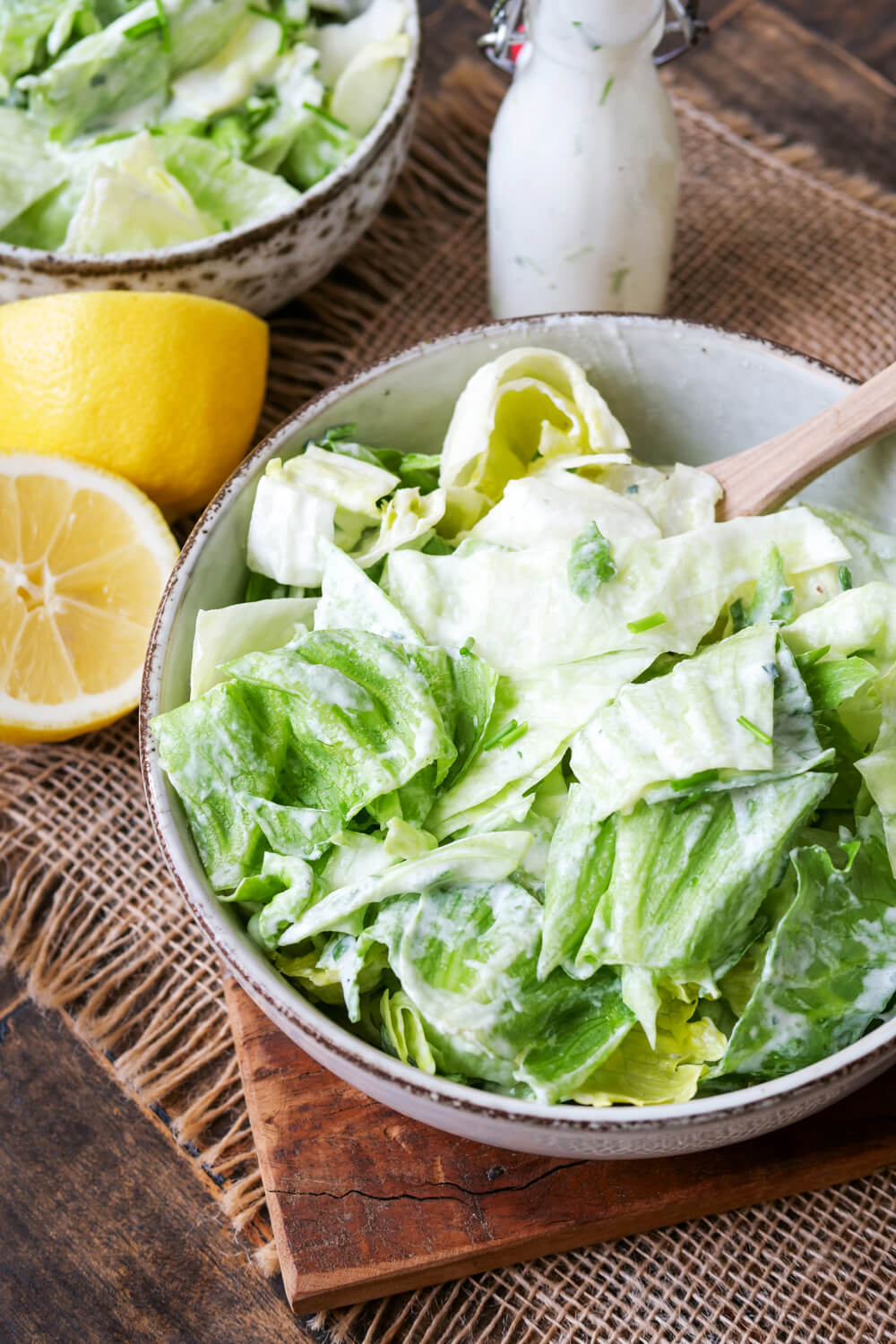 Eisbergsalat in einer Schale mit Holzlöffel.