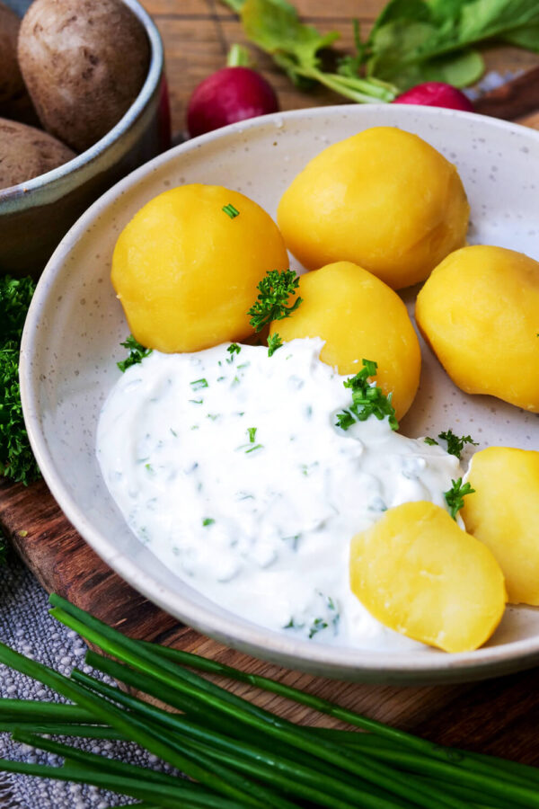 Kartoffeln mit Quark und Petersilie auf einem Teller angerichtet.