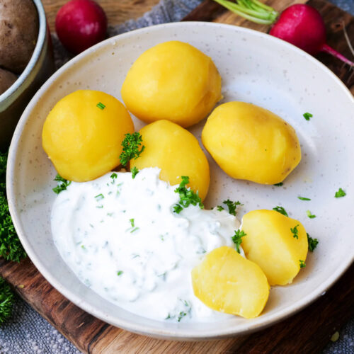 Kartoffeln mit Quark auf einem Teller angerichtet.