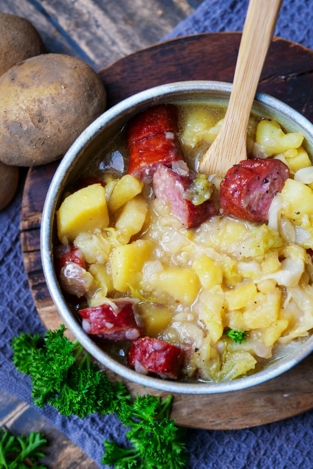 Spitzkohl-Eintopf in einer Schale mit Holzlöffel.