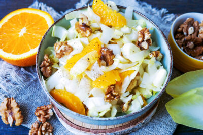 Chicorée-Salat mit Orangen und Walnüssen in einer Schale.