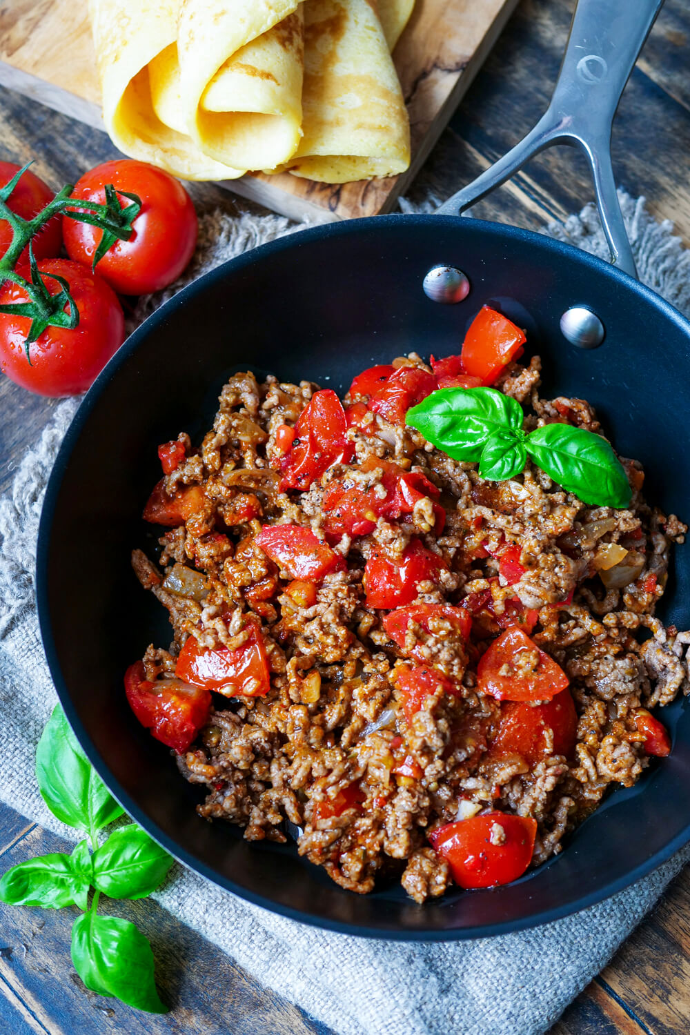 Hackfleischfüllung mit Tomaten und Basilikum in einer Pfanne.