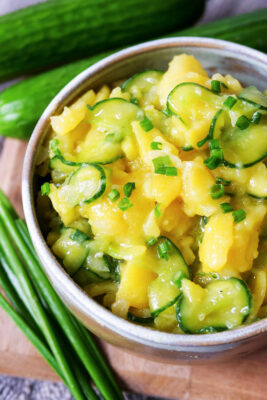 Kartoffel-Gurken-Salat mit Schnittlauch in einer Schale.