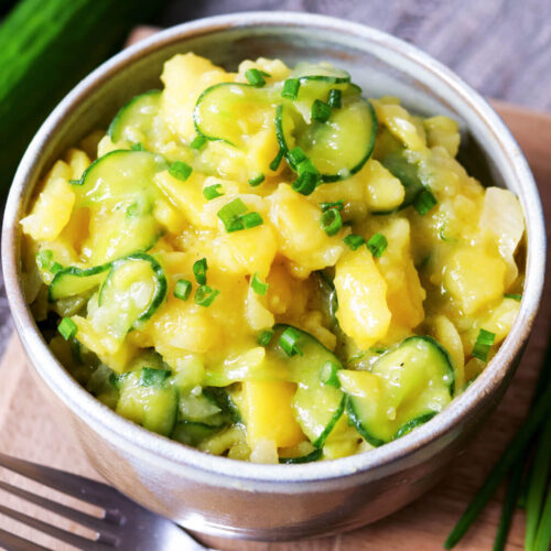 Kartoffel-Gurken-Salat mit Schnittlauch in einer Schale.