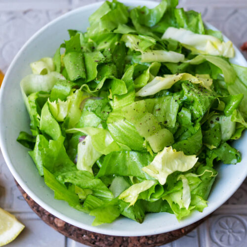 Endiviensalat auf einem Teller mit Dressing-Zutaten drum herum.