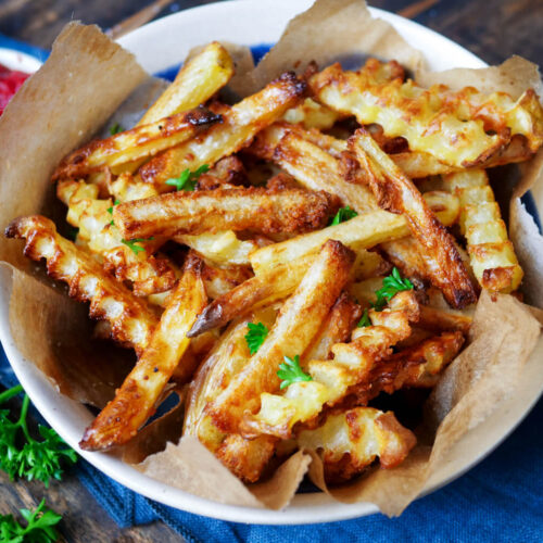 Selbstgemachte, knusprige Pommes mit Petersilie Mayo und Ketchup in der Schüssel