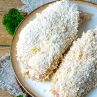 Zwei Hähnchen-Cordon-Bleu paniert auf einem Teller.