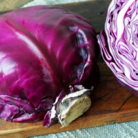 Halbierter Rotkohl auf einem Holzbrett.