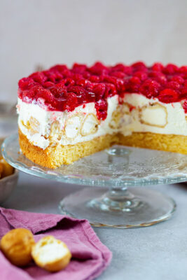 Windbeuteltorte angeschnitten auf einer Kuchenplatte.