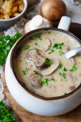 Champignonsuppe in einer Tasse mit Löffel.