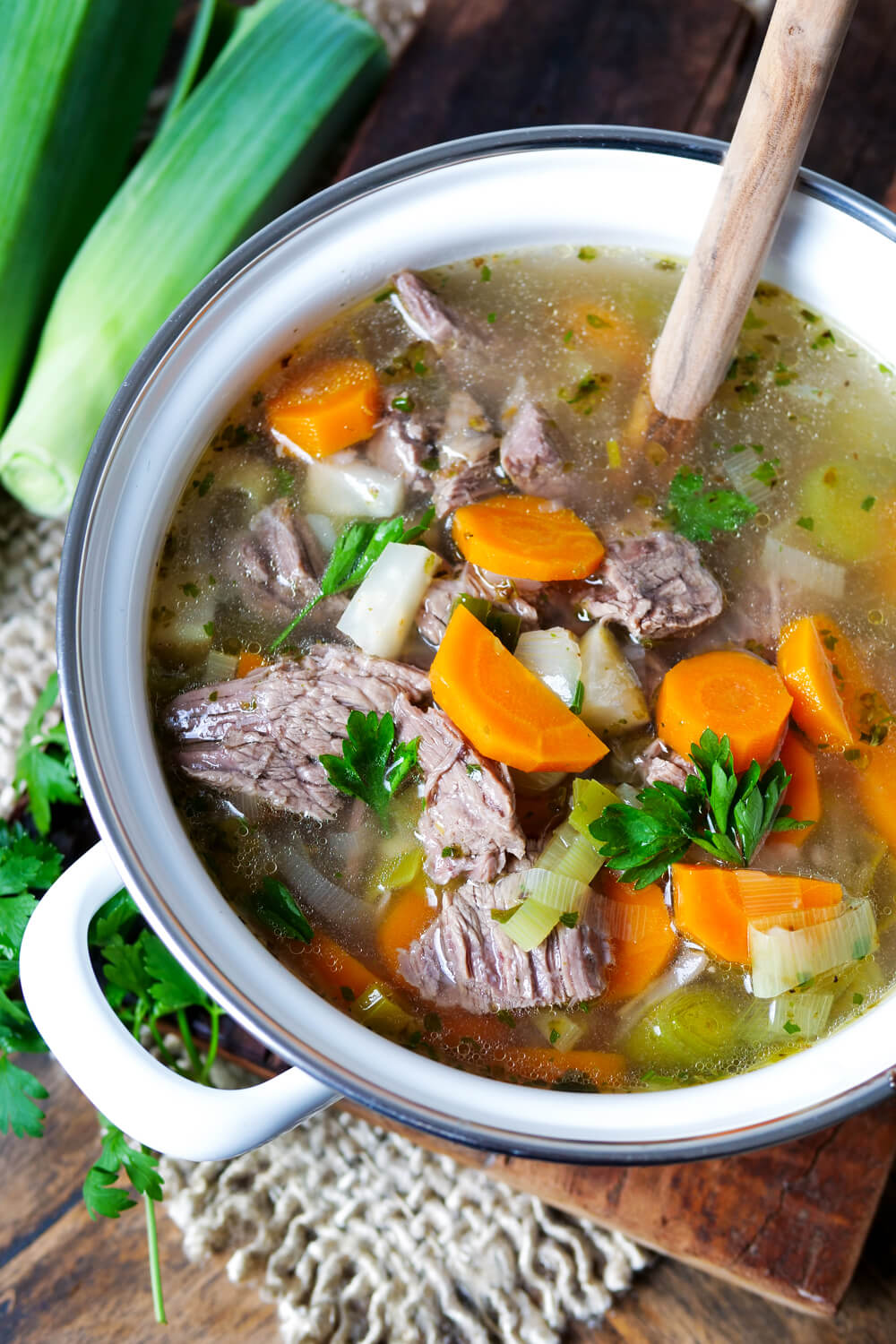 Rindfleischsuppe in einem Topf mit Kochlöffel.