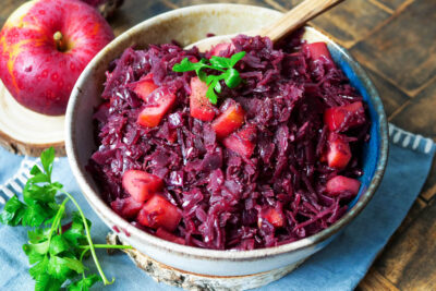 Verfeinerter Rotkohl aus dem Glas mit Apfel in einer Schale.