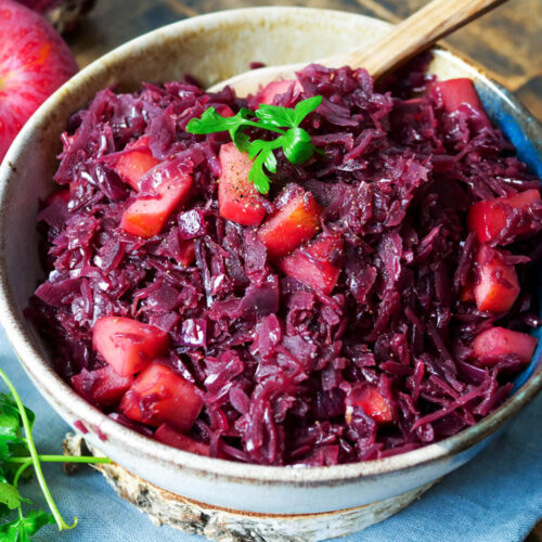 Verfeinerter Rotkohl aus dem Glas mit Apfel in einer Schale.