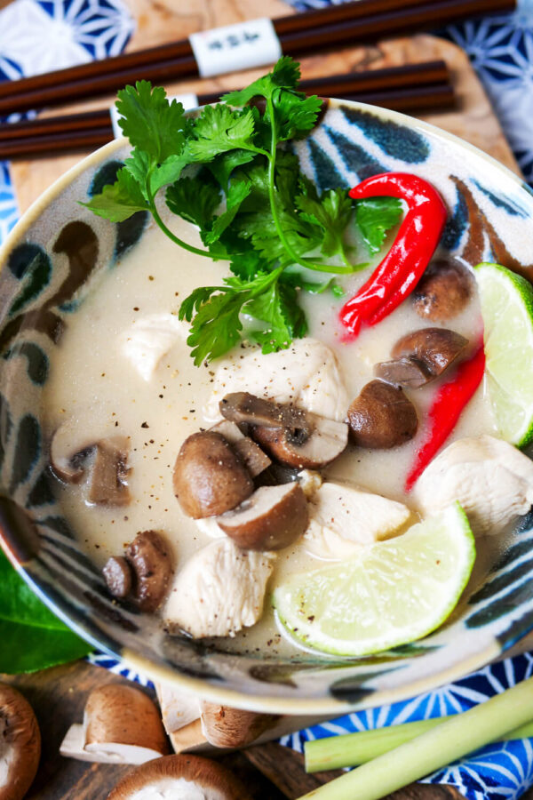 Tom Kha Gai mit Pilzen, Hühnchen, Chili und Koriander in einer Schale.