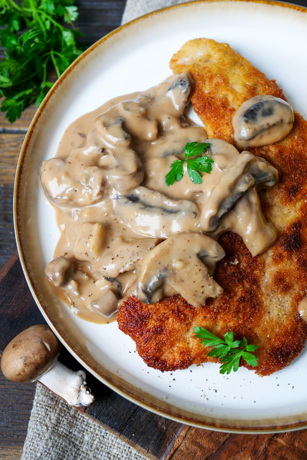 Jägerschnitzel mit Soße auf einem weißen Teller.