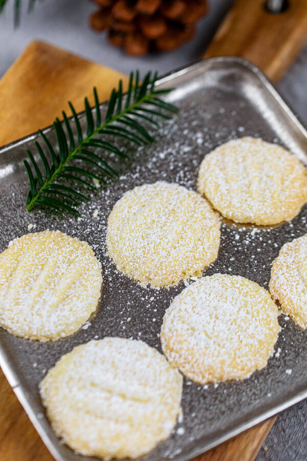 Schneeflocken-Plätzchen mit Tannenzweig auf einem kleinen Blech.